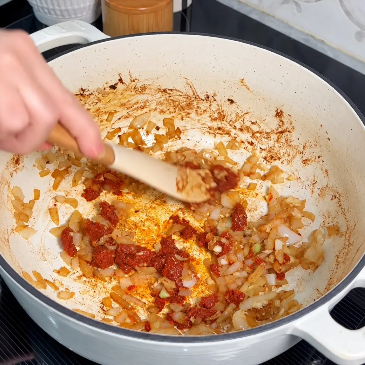 Onions and red curry paste stirred in a white Dutch oven to make the soup base.