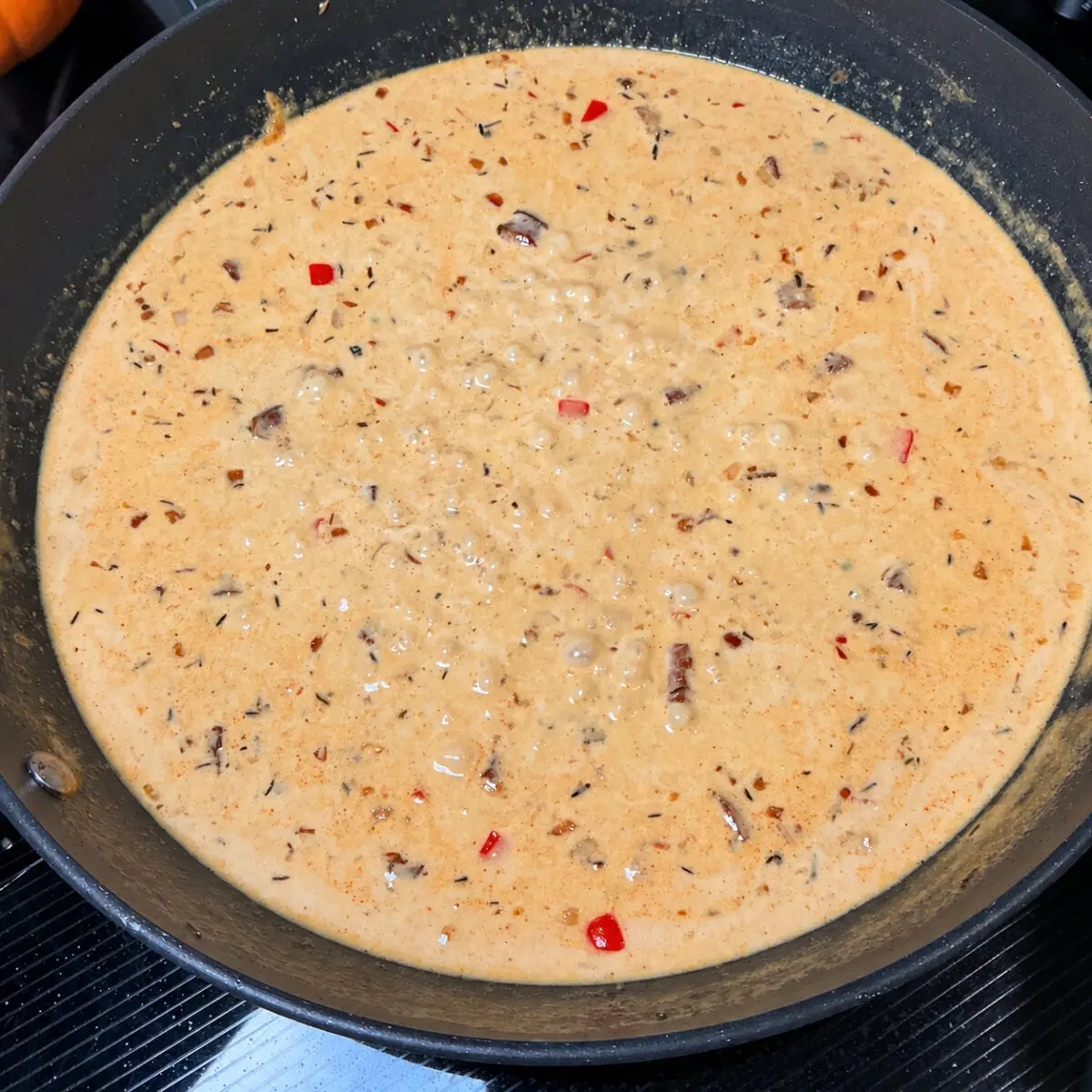 Creamy Cajun peppercorn sauce simmering in a black skillet.